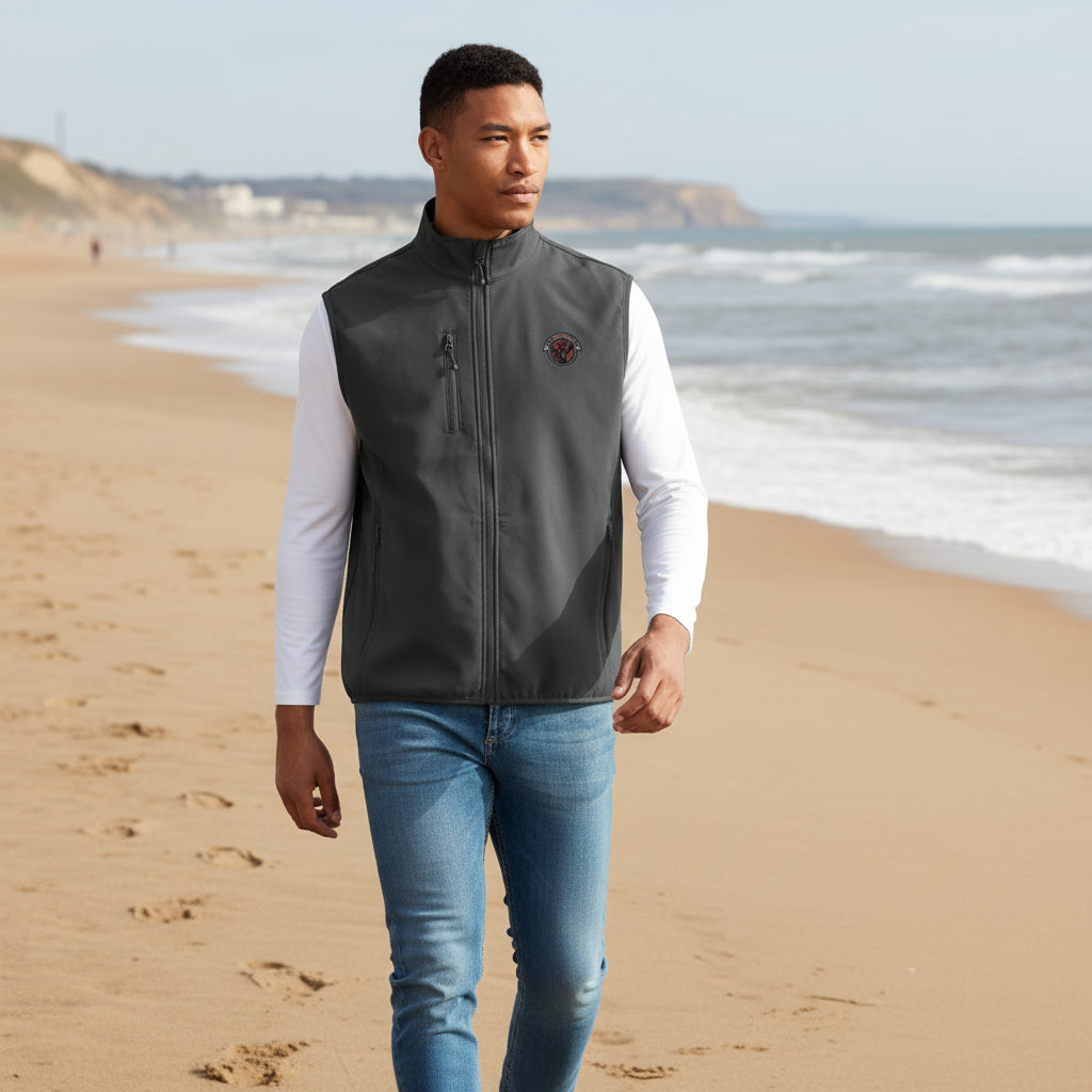 Man wearing a gray vest with a logo on of lets get carried away man, walking along roker beach in sunderland